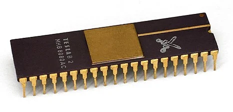 An Intel 8080 compatible microprocessor, a long black chip with two rows of gold pins