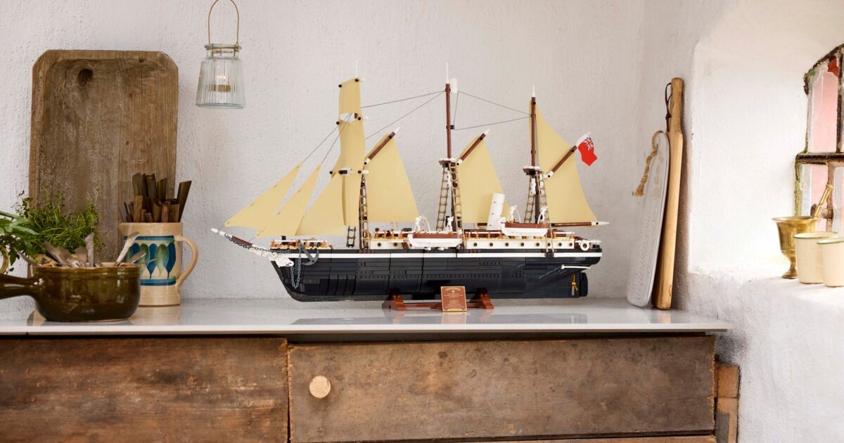 The LEGO Endurance set, a model of Shackleton's three-masted ship with cream sails, on a wooden sideboard