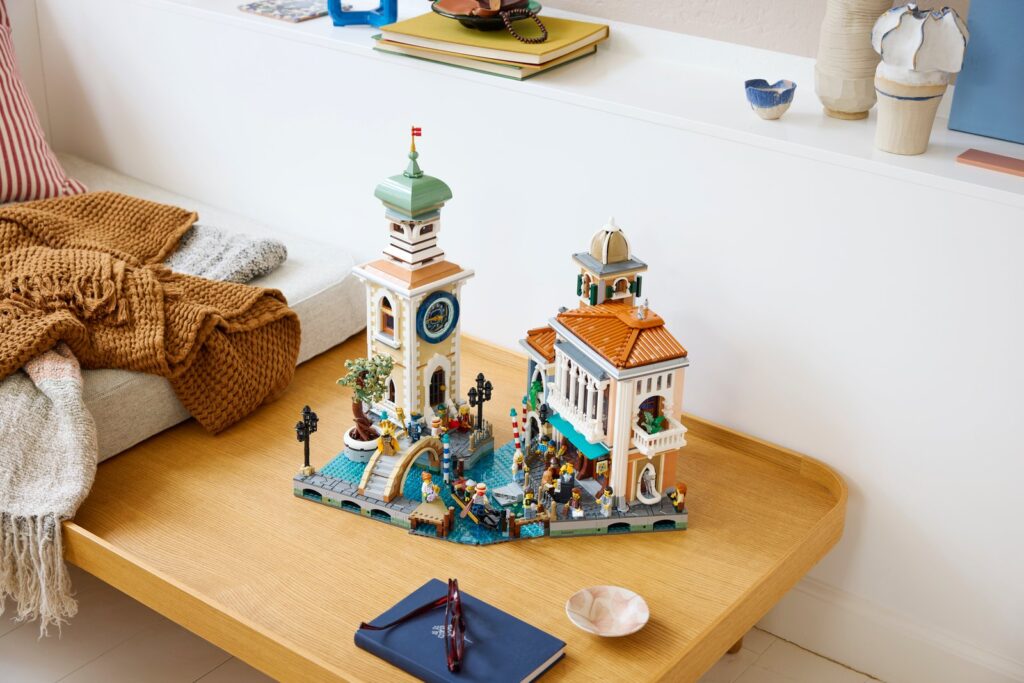 The LEGO Venetian Neighbourhood model on a wooden tray: a clock tower, a villa and canal-side buildings